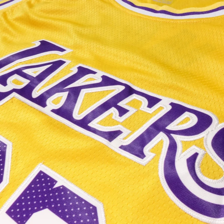 Chữ "Lakers" được thêu sắc sảo với viền tím trên nền vàng nổi bật của áo bóng rổ.